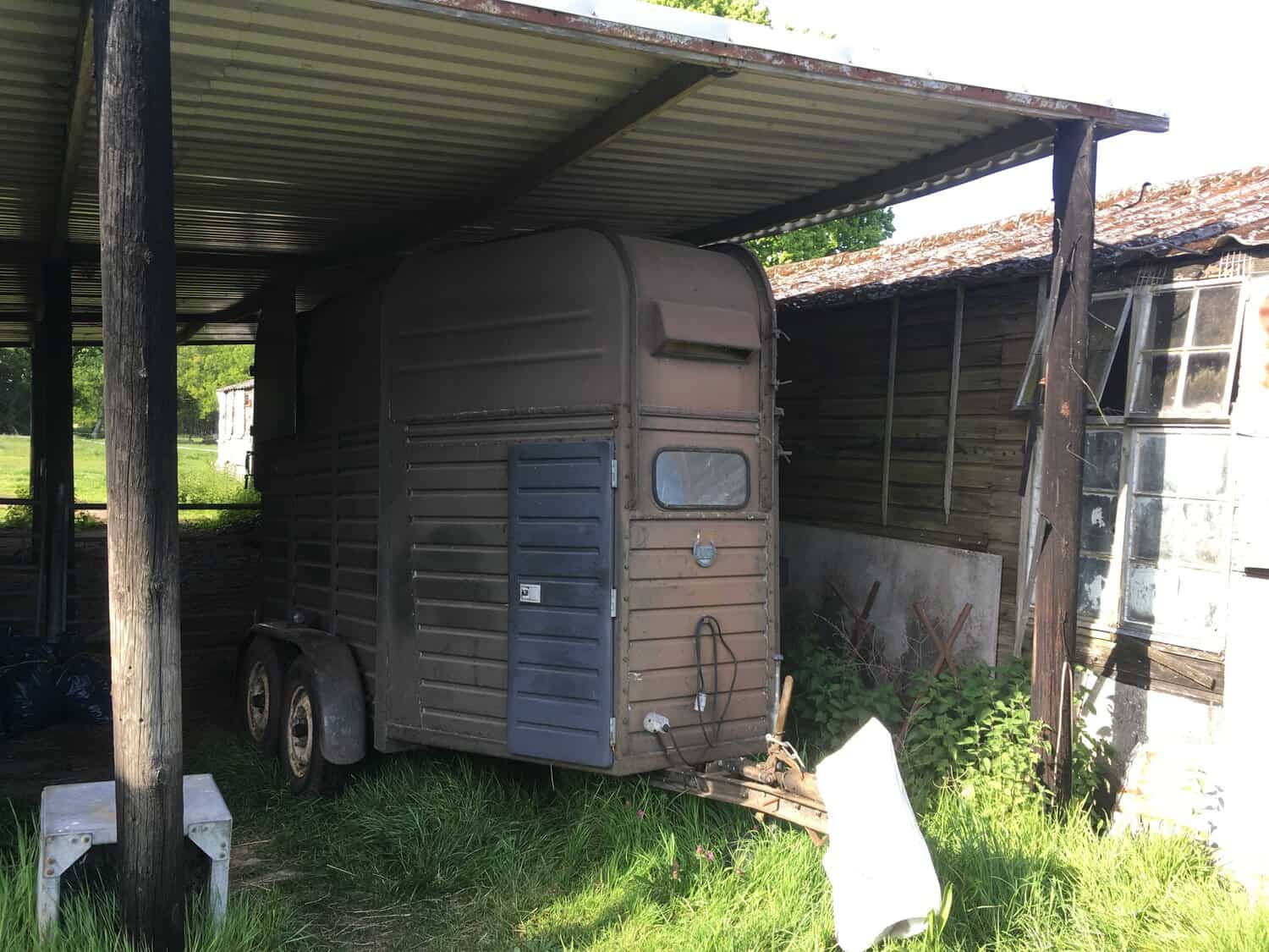 The "brown" horse box under a lean-to